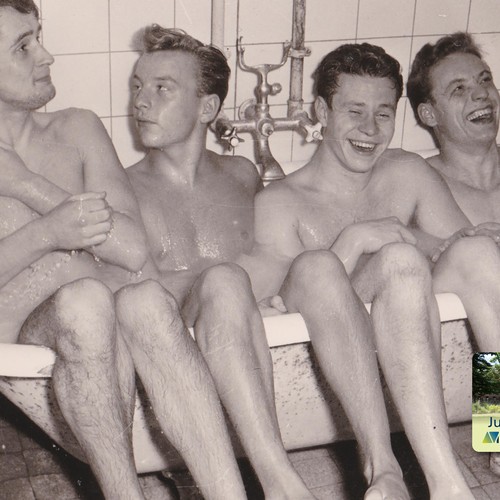 Schwarz-weiß-Fotografie aus den 1950er-Jahren. Zu sehen sind vier junge Männer, die seitlich nebeneinander in einer Badewanne sitzen